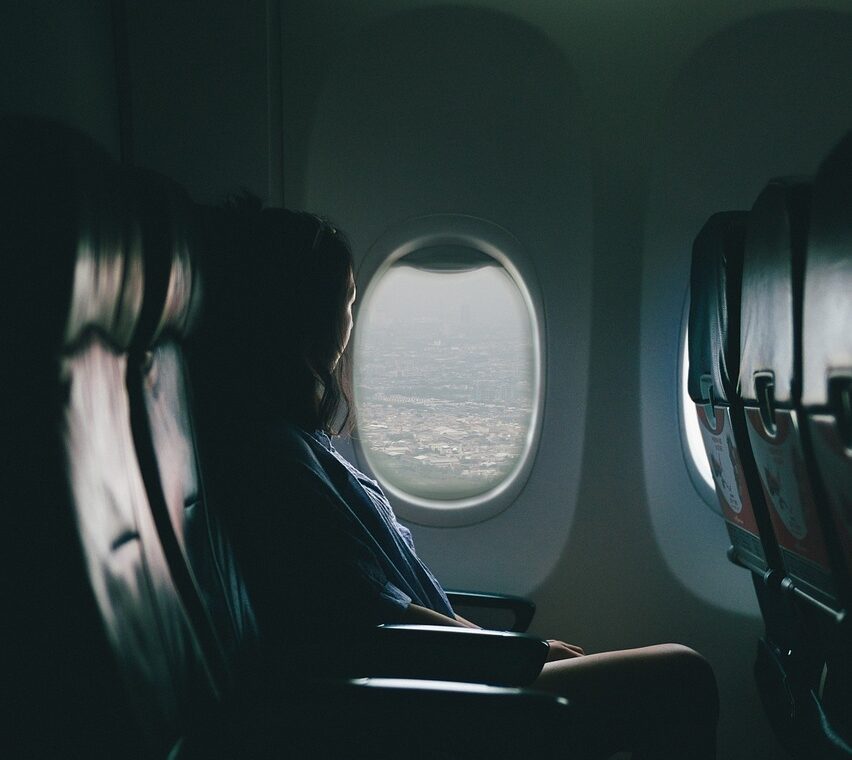 Woman looking out of a plane from her window seat.