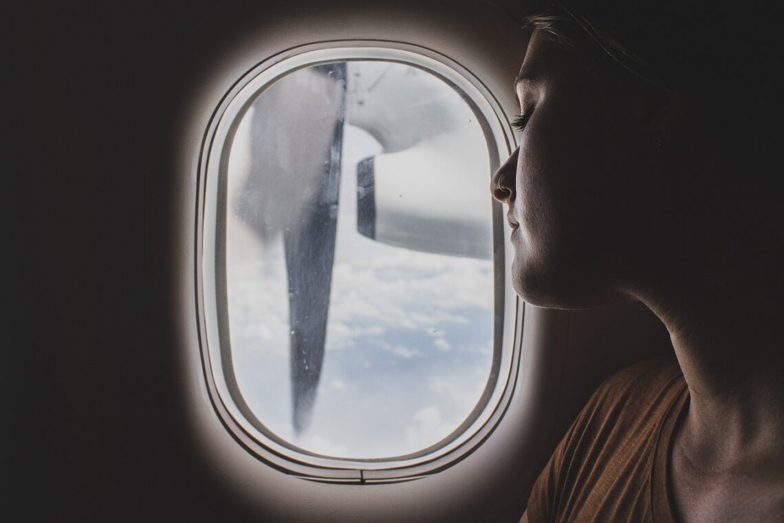 Woman sleeping on a plane by the window seat